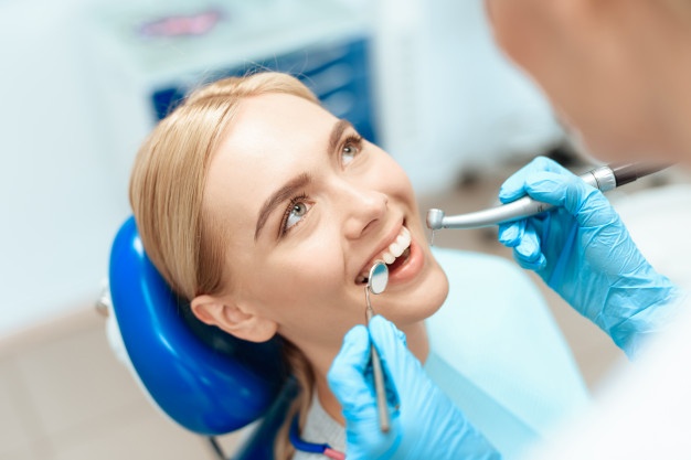 dentist-examines-girl-chair_85574-14997